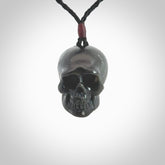This picture shows a medium sized Black Obsidian stone skull pendant that we have hand carved. It is polished to a soft shine and is a very striking piece. Provided with an adjustable black cord.